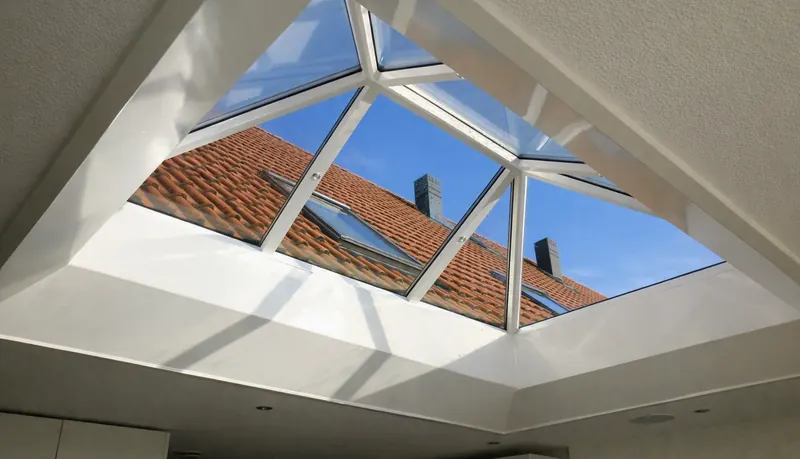 Piramidevormige lichtkoepel in het dak van een aanbouw, van binnenuit gezien