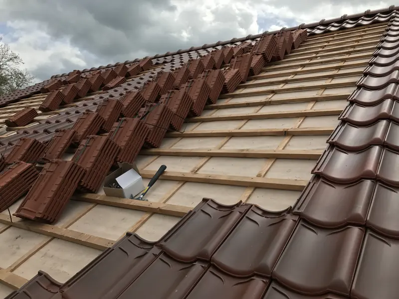 Roodbruine pannen worden op de panlatten gelegd, schuur bij het hertenkamp in Hoogwoud