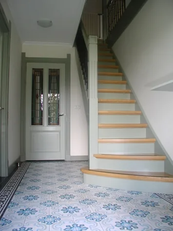 Hal met tegelvloer in blauw motief en trap met houten treden, woonhuis in Opmeer