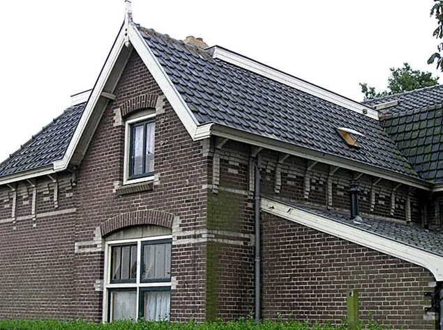 Bakstenen gevel met witte windveren, siermetselwerk onder de goot en pannendak, stoomgemaal in Medemblik