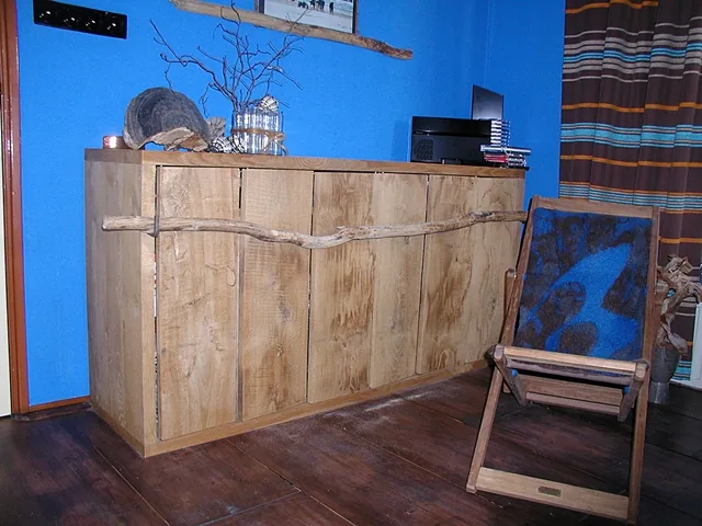 Dressoir van brede houten planken met een boomtak als greep